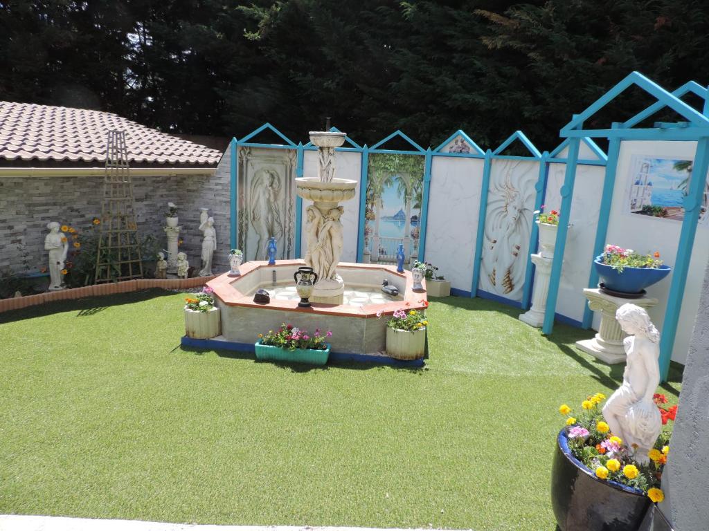 einen Garten mit einem Brunnen inmitten eines Gartens in der Unterkunft Chez Papy et Mamy in Saint-Chef