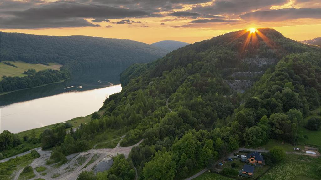 an aerial view of a mountain with a river and the sunset at Leśniakówka 693-664-683 in Solina