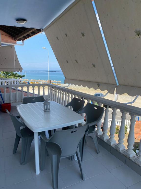 einen Tisch und Stühle auf einem Balkon mit Meerblick in der Unterkunft Tsatsoni - Anastasiou Studios in Velika