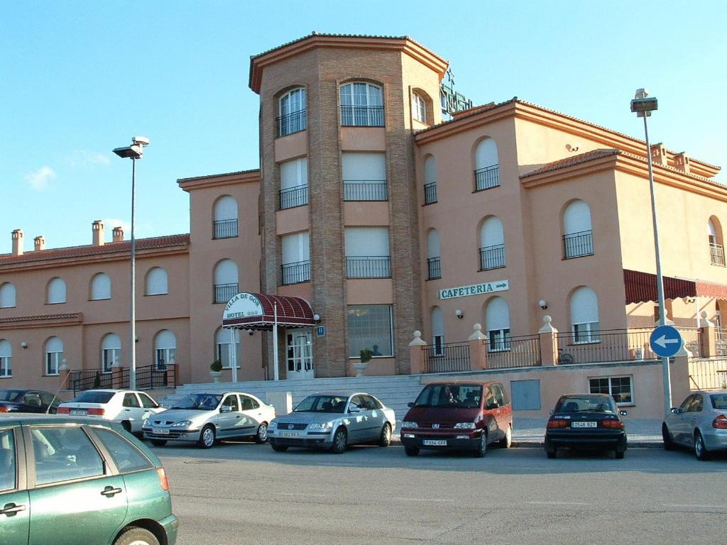 um grande edifício com carros estacionados em frente em Villa de Gor em Gor