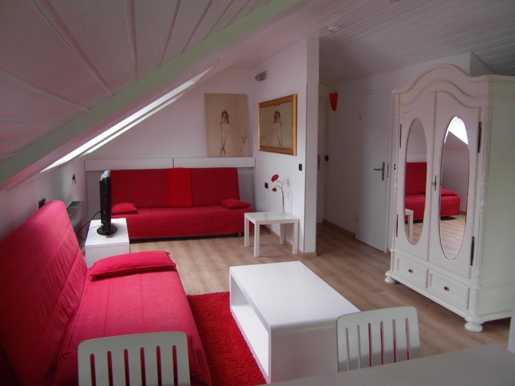 a living room with red furniture and a red couch at Ferienwohnungen Gabi Karnowski in Gernsbach