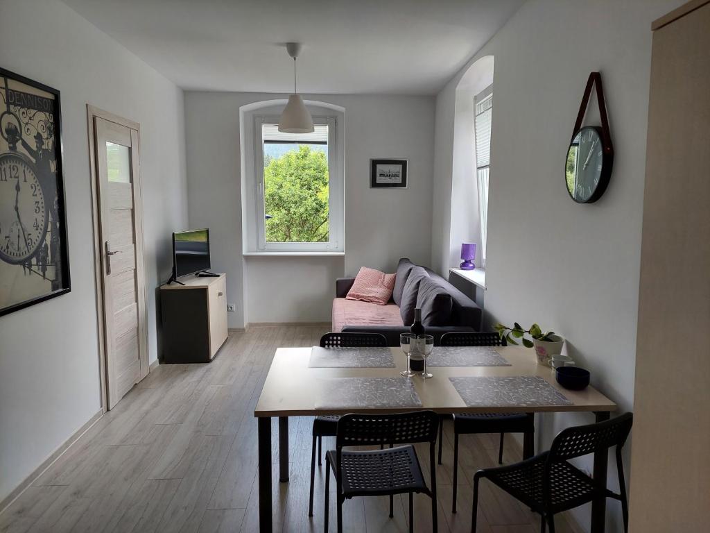 a living room with a table and a couch at Apartament Jedlinka in Jedlina-Zdrój