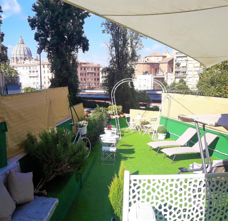 um pátio com cadeiras e mesas no telhado em San Pietro Shabby Chic Apartment em Roma