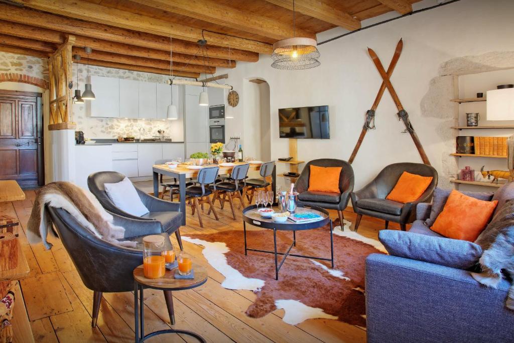 a living room with chairs and tables and a kitchen at Le SwansDoors - OVO Network in Annecy