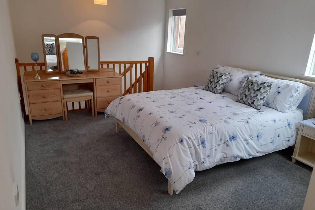 sypialnia z łóżkiem, komodą i lustrem w obiekcie Town centre cottage w mieście Tewkesbury