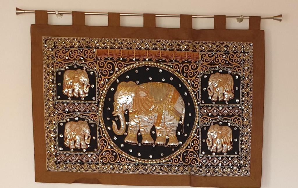 a frame of gold elephants on a wall at Glückselefant 01 in Heringsdorf