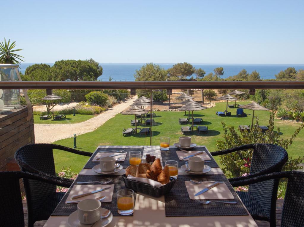 a table on a balcony with a view of the ocean at Vila Alba Resort in Carvoeiro