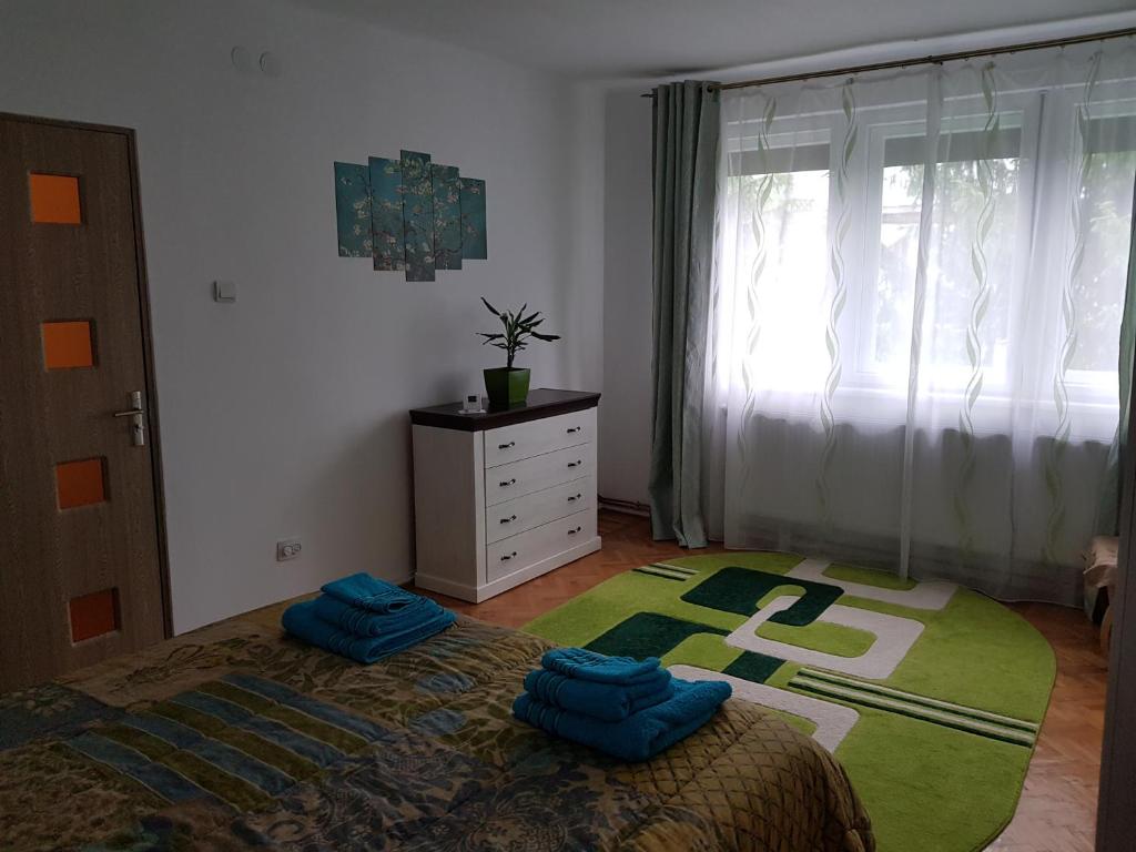 a bedroom with a bed and a dresser and a window at Aris Apartment in Hunedoara