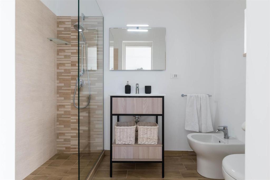 a bathroom with a glass shower and a sink at Casetta Mare in Villanova di Ostuni
