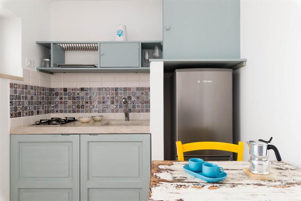 a kitchen with a table and a refrigerator at Casetta Mare in Villanova di Ostuni