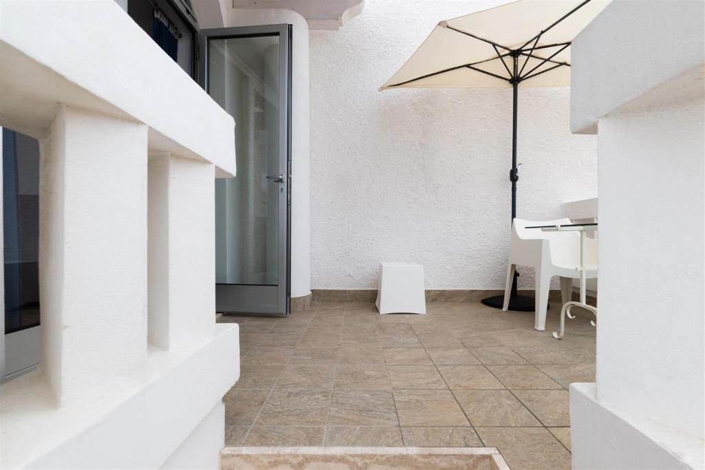 a hallway with a table and an umbrella at Casetta Mare in Villanova di Ostuni