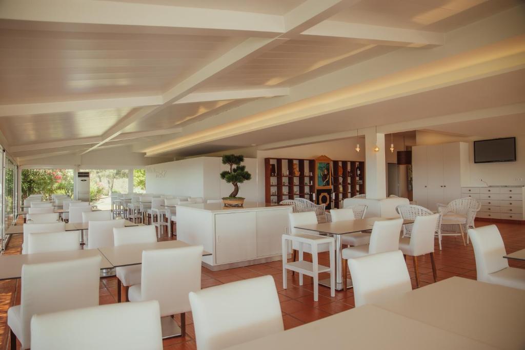 a restaurant with white tables and white chairs at Vila Alba Resort in Carvoeiro