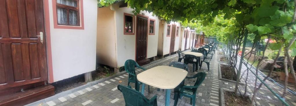 uma fila de mesas e cadeiras ao lado de um edifício em Casa Mihai em Costinesti