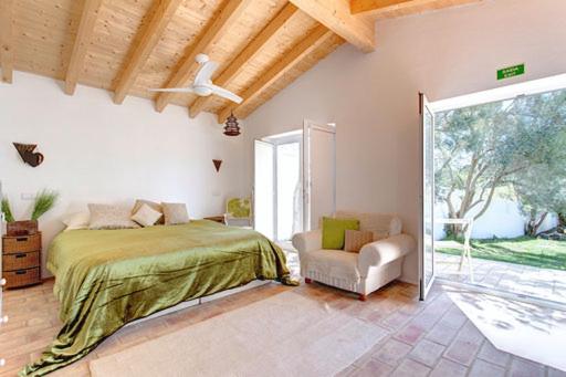 1 dormitorio con 1 cama, 1 silla y 1 ventana en Casa De Mondo, en Boliqueime