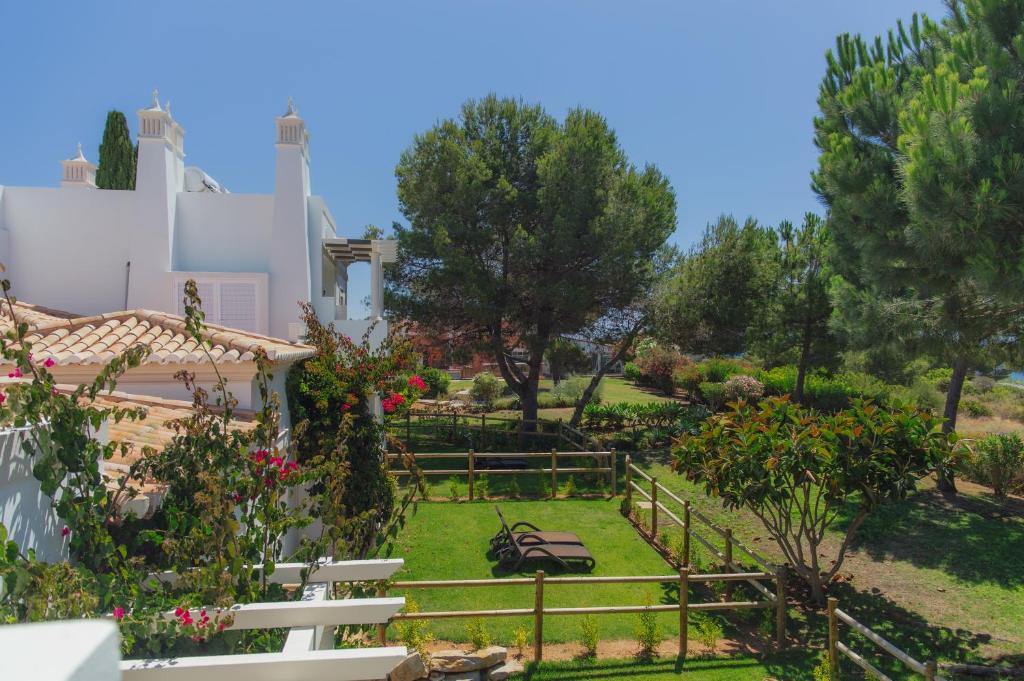 a garden in front of a house with trees and flowers at Vila Alba Resort in Carvoeiro