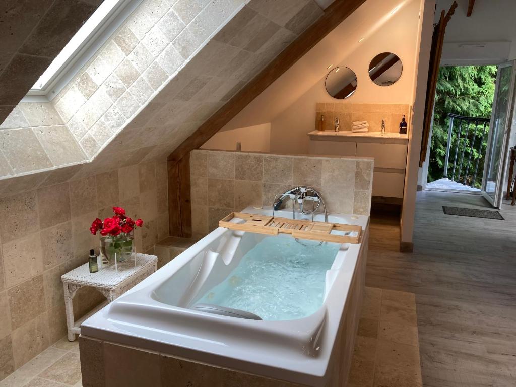 a bathroom with a bath tub with a sink at A 2 heures de Paris, Loft Romantique de 55 m2 en pleine nature entre campagne et mer in Saint-Philbert-des-Champs