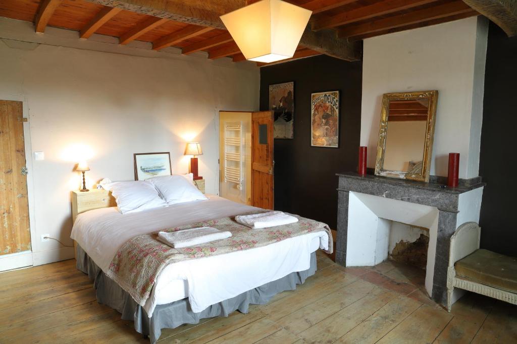 a bedroom with a large bed and a fireplace at La Maison de Louis in Francon