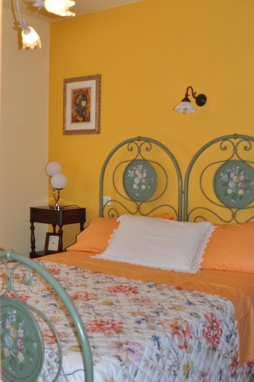 a bedroom with a bed with an orange bedspread at Casa Ben Essere in Cuccurano