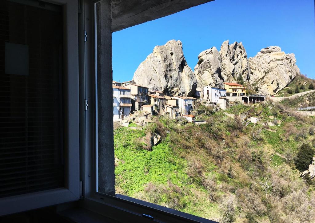 een raam met uitzicht op een berg bij lupo in Pietrapertosa