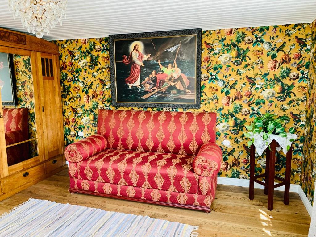 a living room with a red couch and a painting at Boutique Villa MAMELFA in Tiheda