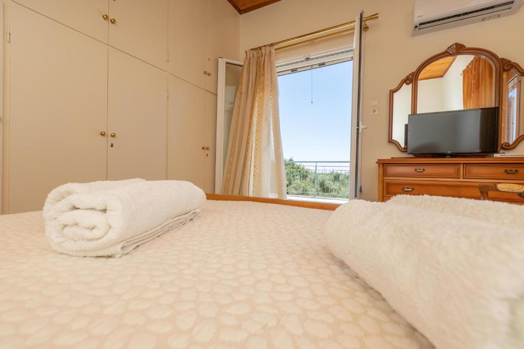 a bedroom with a bed with a mirror and a television at Elaianthos 1 in Gythio