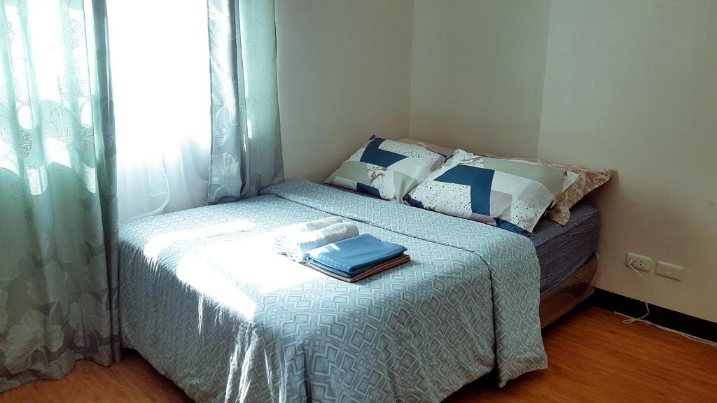 a small bedroom with a bed and a window at Keys 'N Places Holiday Rentals at Mesaverte Condo in Cagayan de Oro
