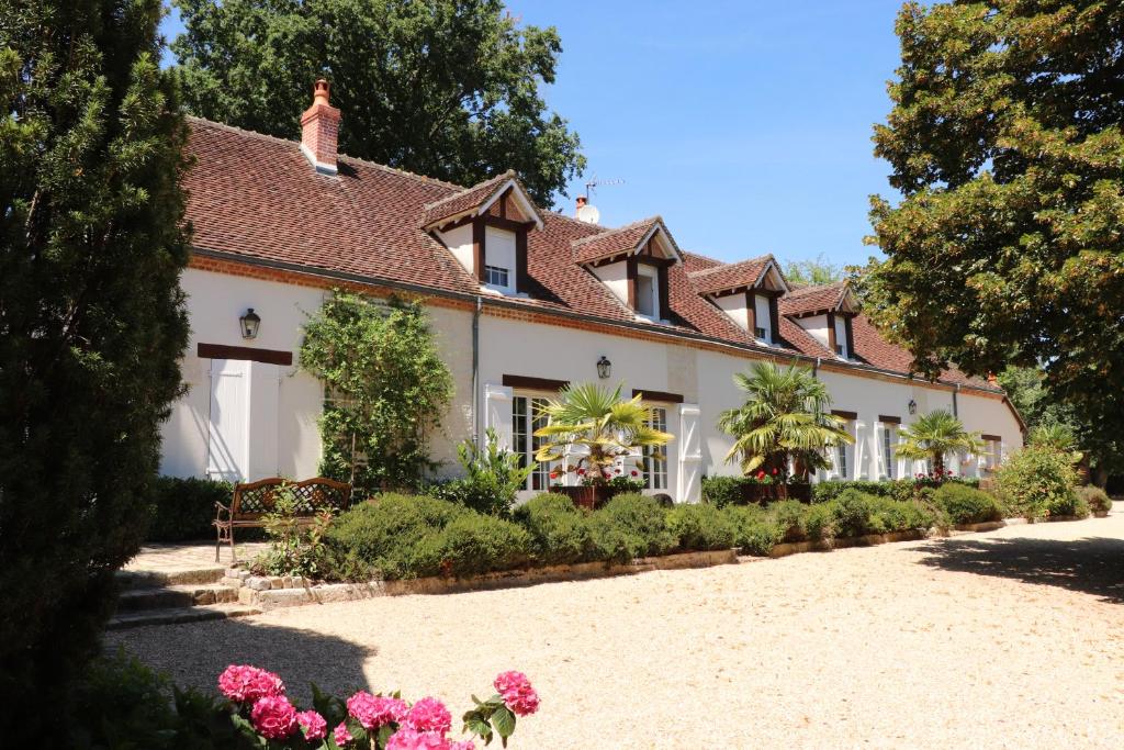 una gran casa blanca con flores delante en les bruyères, en Méry-sur-Cher