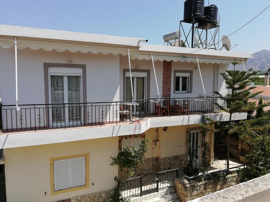 a white house with a balcony at NEON Apartment, spacious, fully equipped, high-quality Apt with balcony, Messara Plain, south Crete in Vayioniá