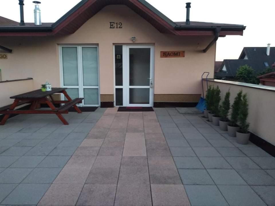 un patio con una mesa de picnic y una casa en Apartman NAOMI E12, en Nová Lesná