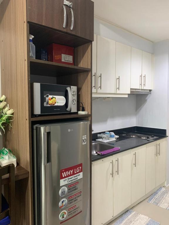 a kitchen with a refrigerator with a microwave on top at 1 BR CONDO SEA RESIDENCES in Manila