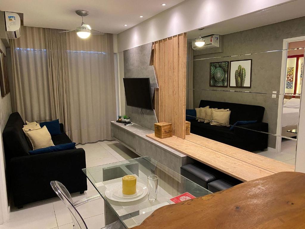 een woonkamer met een tafel en een tv in een kamer bij Edifício Time Apto 709 ER Hospedagens in Maceió