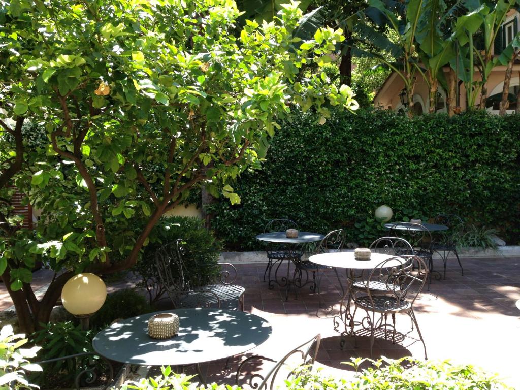 a group of tables and chairs under a tree at Hotel Select Garden in Rome