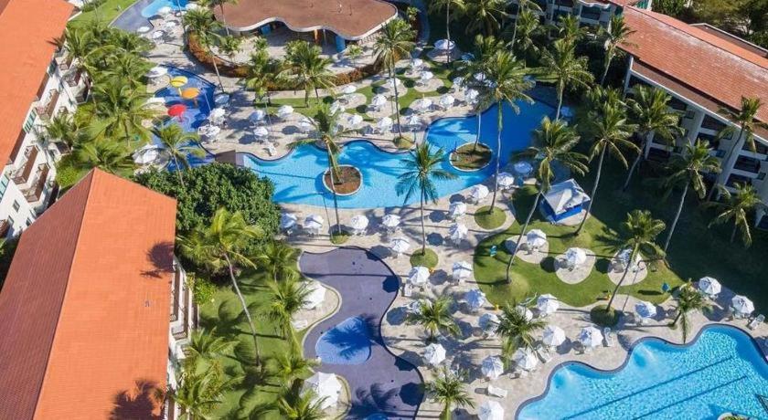 Studio Experience Marulhos Resort في بورتو دي غالينهاس: اطلالة جوية على منتجع مع مسبح