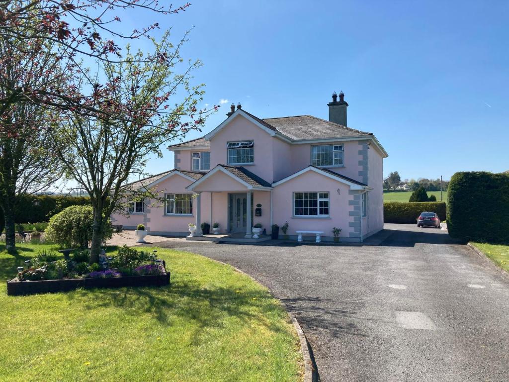 uma grande casa branca com uma entrada em Tir Na Nog B&B em Cashel