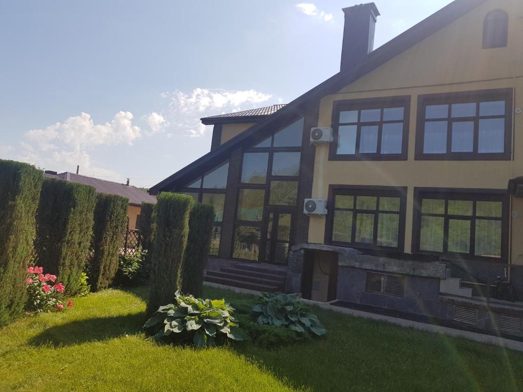 a house with windows and a yard with flowers at Гостевой дом Мелодия Жигулей, Самарская область, село Жигули in Zhiguli