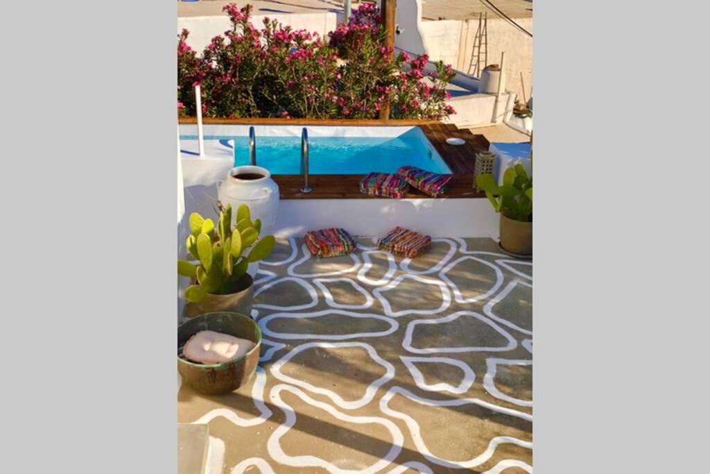 a view of a patio with a pool and plants at The Summer Pink House in Lachania