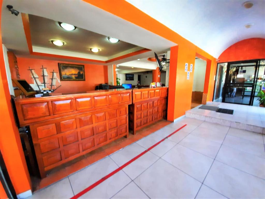 comedor con paredes de color naranja y suelo de baldosa blanca en Hotel Costa Maria, en Ciudad del Carmen