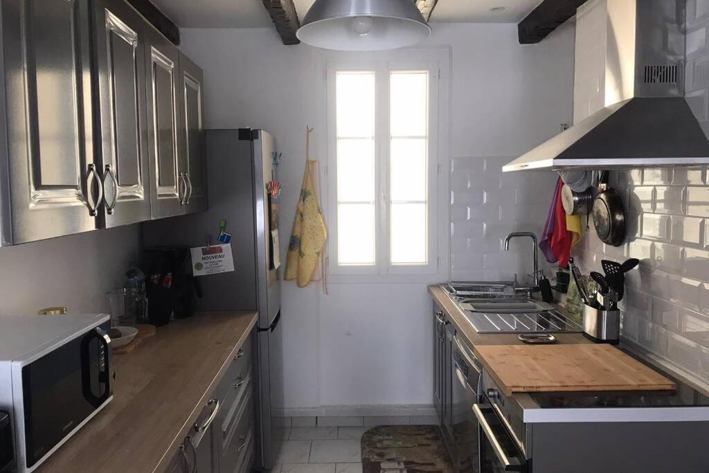 een keuken met een wastafel en een fornuis top oven bij La petite oasis, newly renovated in Toulon