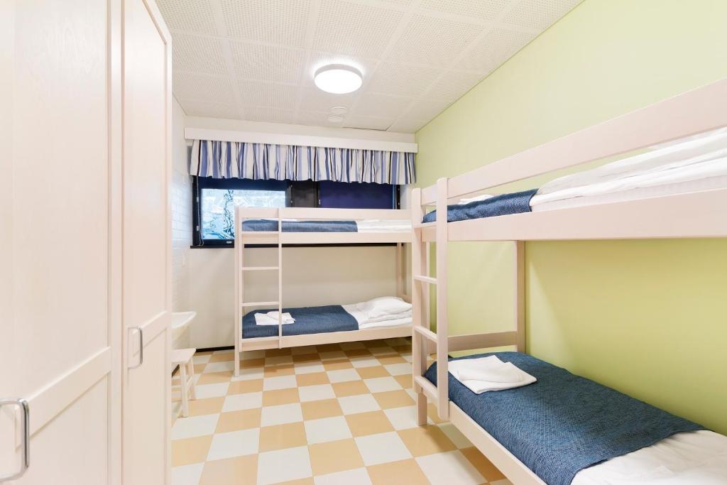 a bunk room with two bunk beds and a checkered floor at Imatra Spa Sport Camp in Imatra