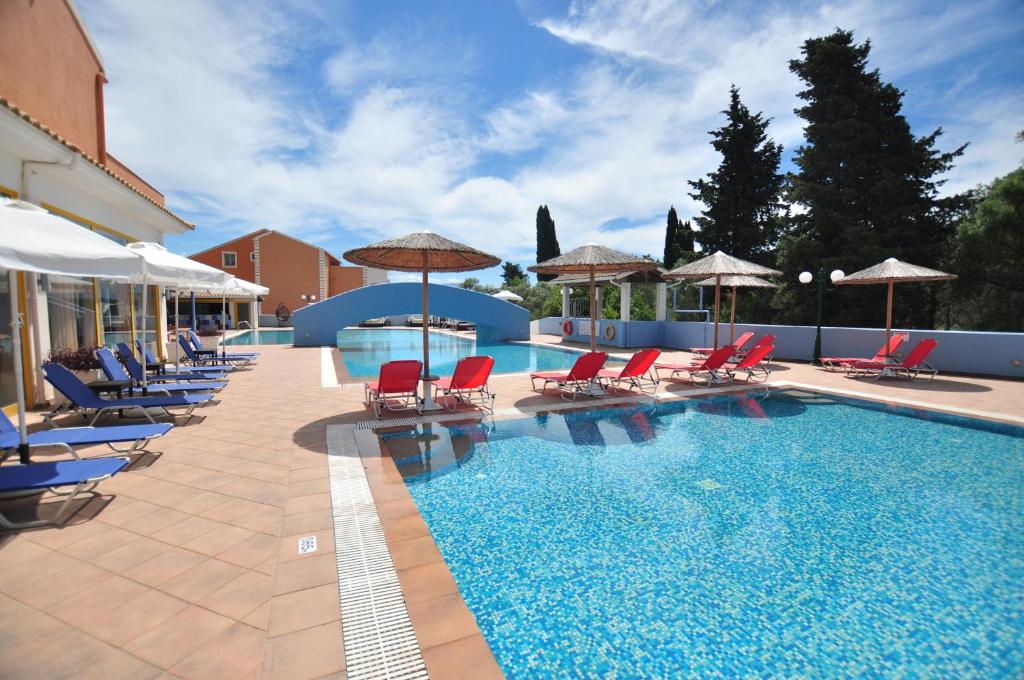 a large swimming pool with chairs and umbrellas at Michelangelo Resort in Kassiopi