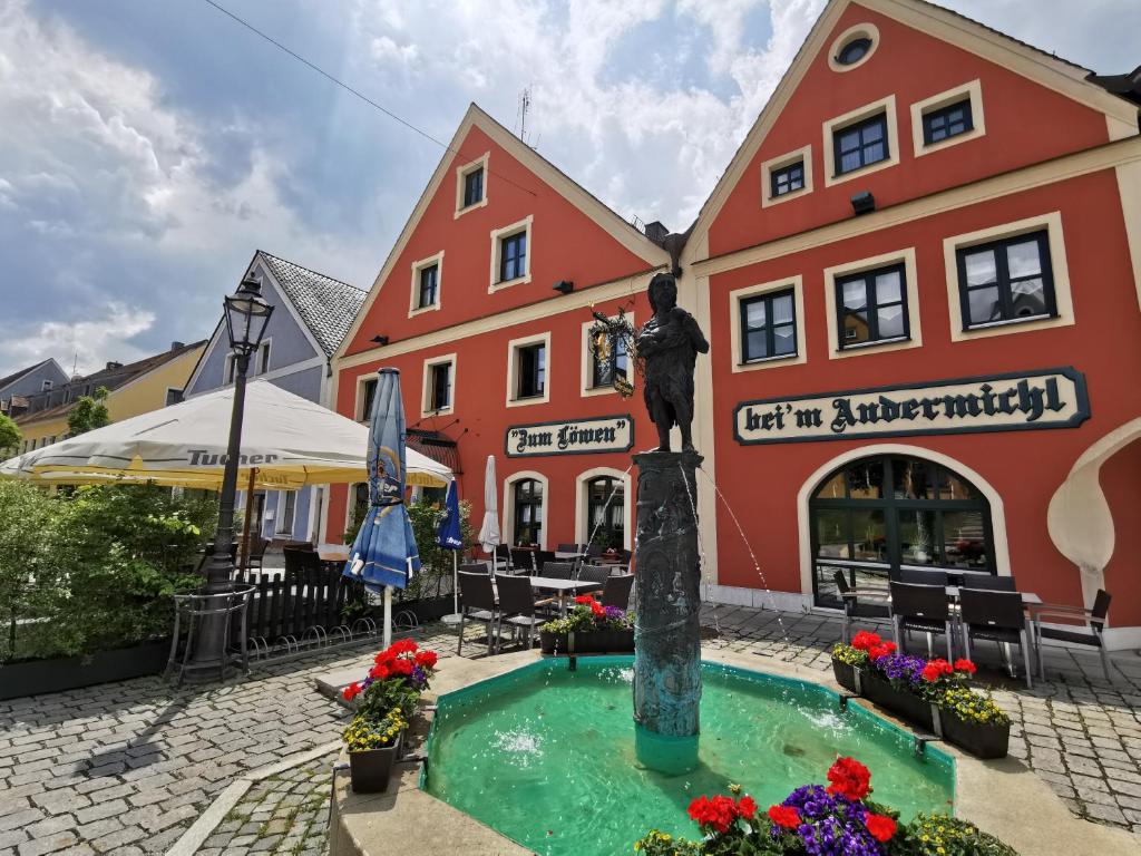 uma estátua numa fonte em frente a um edifício em Hotel Gasthof Zum Löwen em Velburg