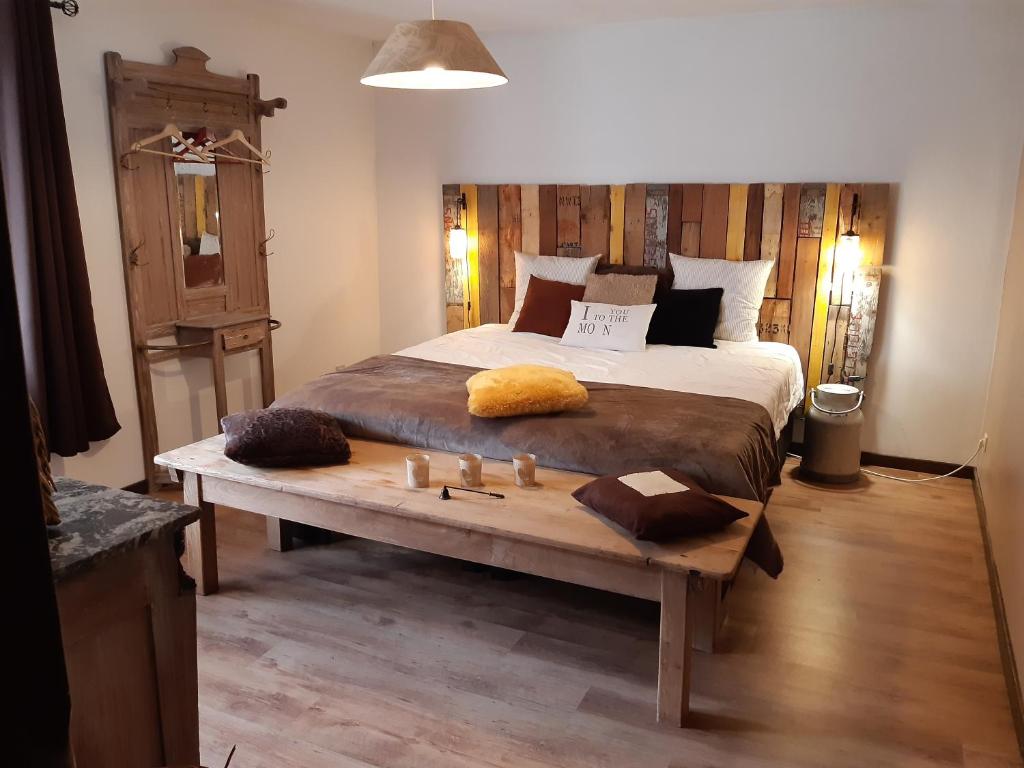 sypialnia z dużym łóżkiem i drewnianym stołem w obiekcie La Pause w mieście Plombières