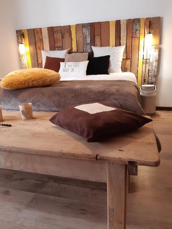 a large bed sitting on a wooden table in a bedroom at La Pause in Plombières