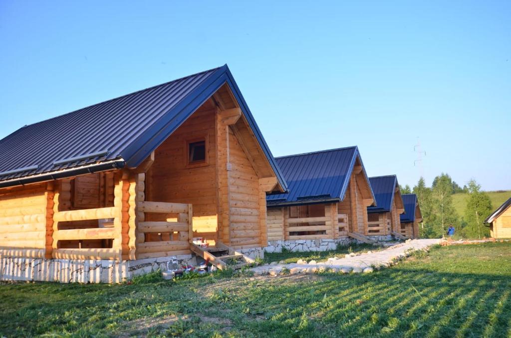 a log cabin with solar panels on its roof at Vidikovac Uvac in Družiniće