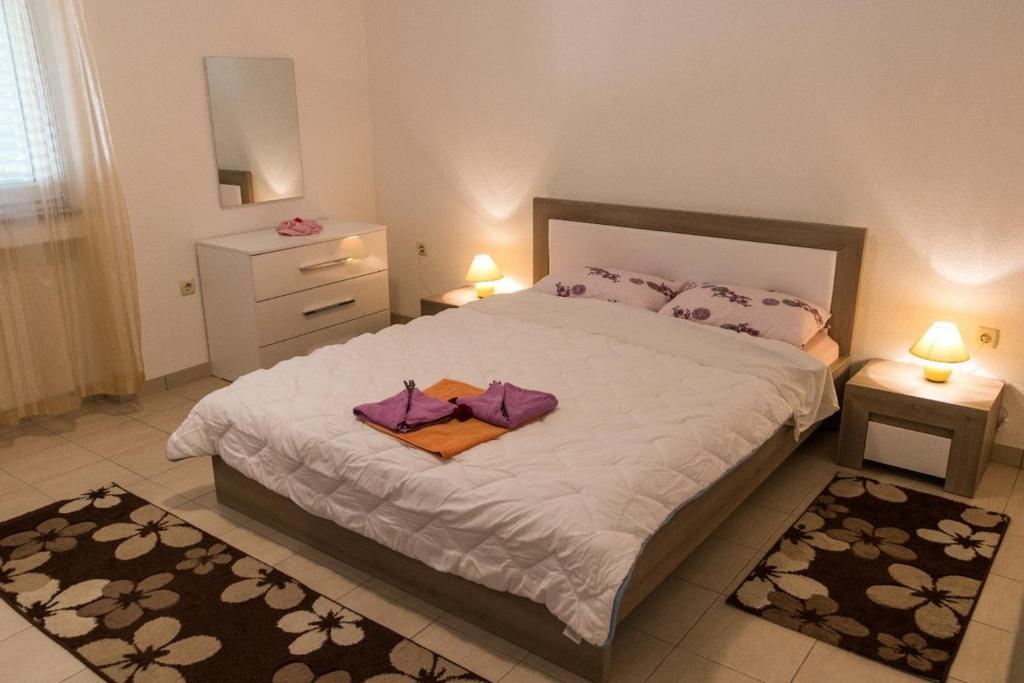 ein Schlafzimmer mit einem großen Bett mit zwei Handtüchern darauf in der Unterkunft Apartment in Mundanije with terrace, air conditioning, WiFi (4912-2) in Mundanije