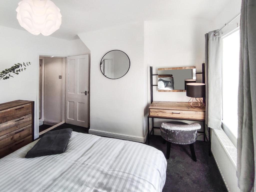 a bedroom with a bed and a desk and a mirror at 'Number 11' Central Colchester - Super Convenient 2 x Double Bed 1 x Single Bed Cottage PLUS Office & Garden, 8 min walk Nth Station & Town Ctr, 2 min walk local shops & restaurants in Colchester