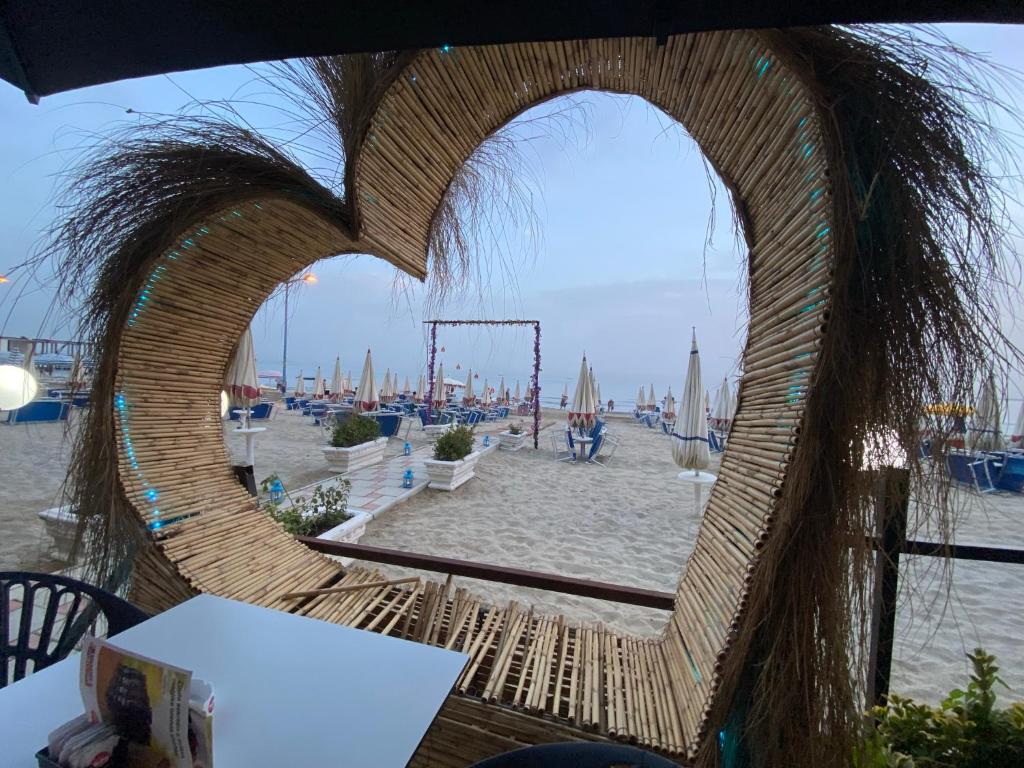 a wooden heart shaped window with a view of a beach at Hotel Alion in Durrës