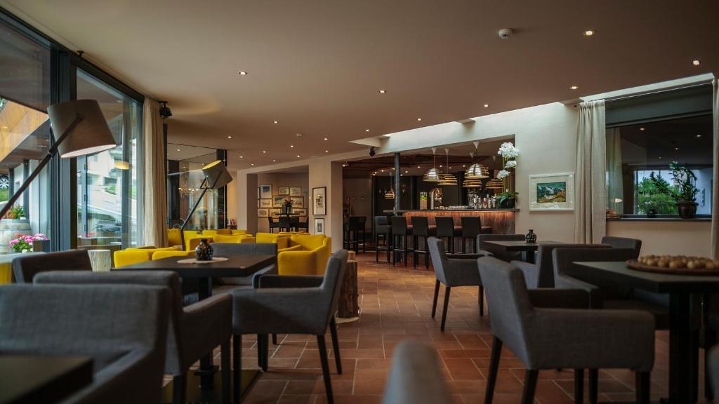 聖瓦倫蒂諾－阿拉穆塔的住宿－施托克爾酒店，一间带桌椅的餐厅和一间酒吧