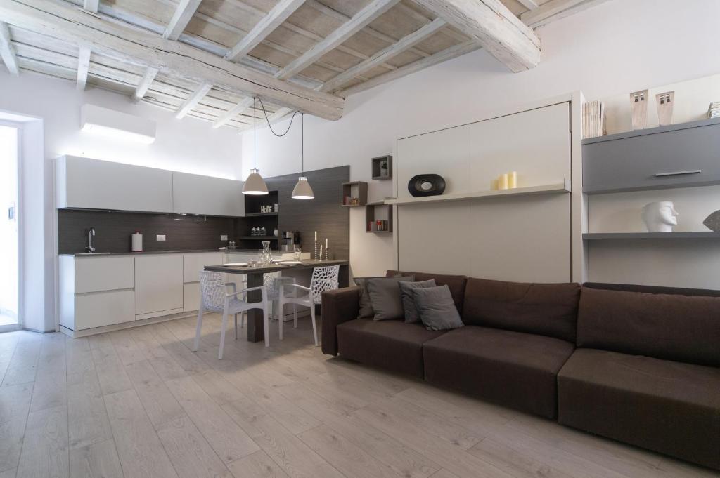 a living room with a couch and a kitchen at Palazzo RICCA GUARDUCCI 1 in Montefiascone