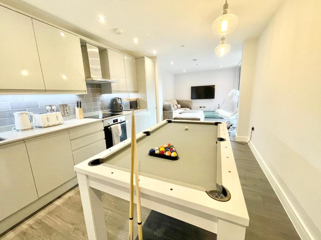 eine Küche mit einem Billardtisch in einem Zimmer in der Unterkunft D & D Luxury Apartments in Stanmore
